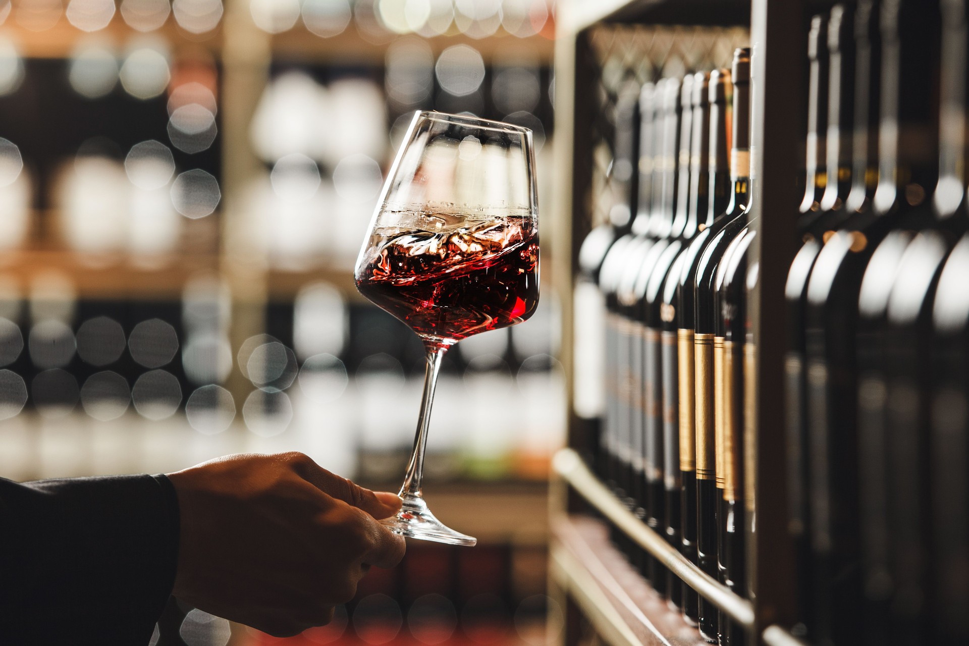 Close-Up View of Person Swirling Red Wine in Cellar Atmosphere
