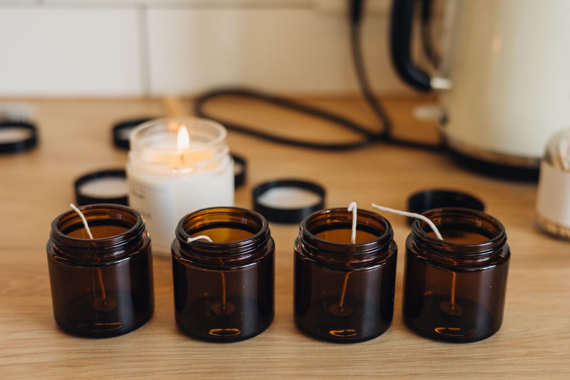 The glass jars are prepared for pouring hot melted wax to create homemade candles